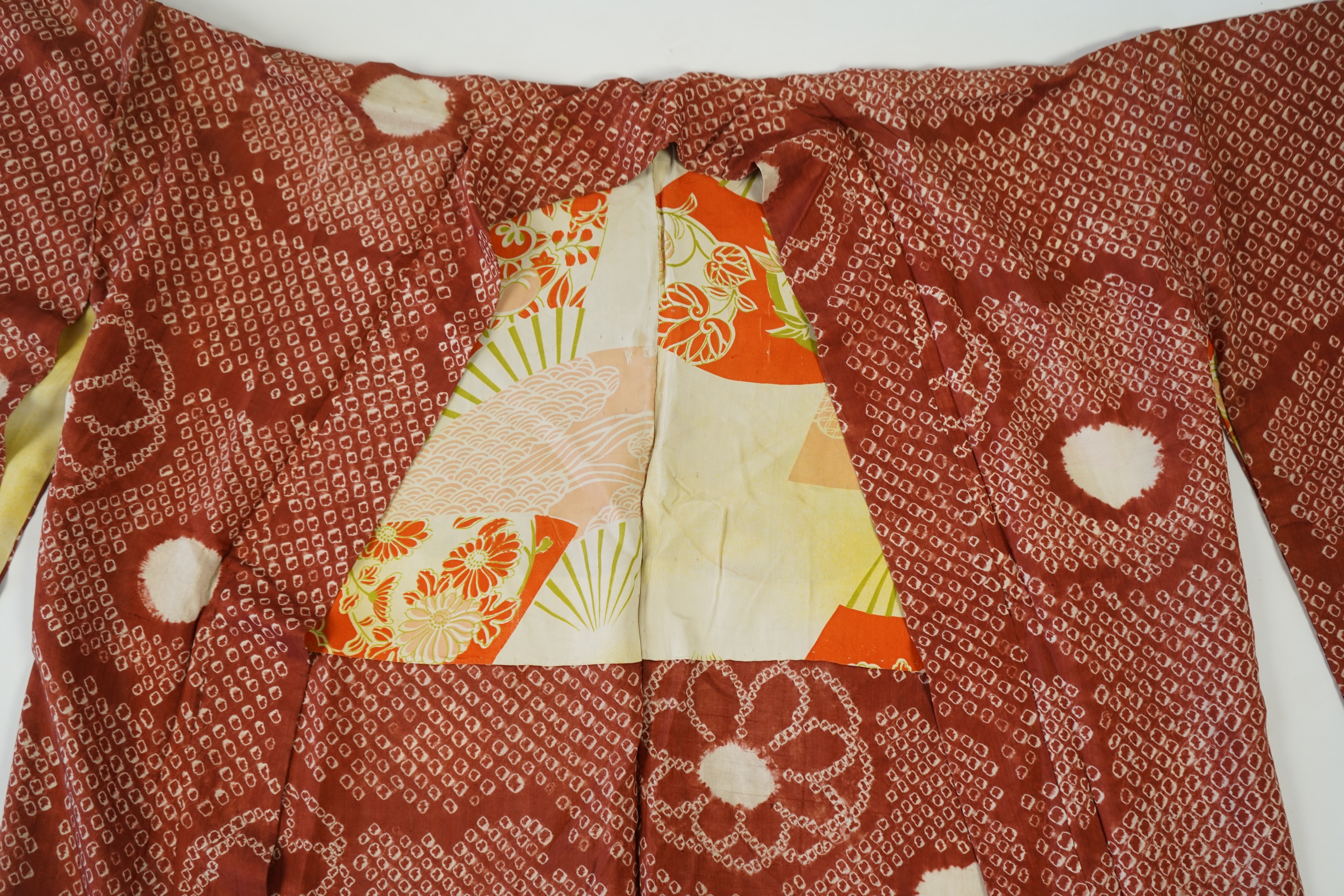 Three Japanese mid 20th century ‘Haori’ printed silk jackets. One red with brightly coloured lining and rust brown floral silk lining. All with large kimono sleeves. Grey patterned Haori, 79cm long., Condition - good